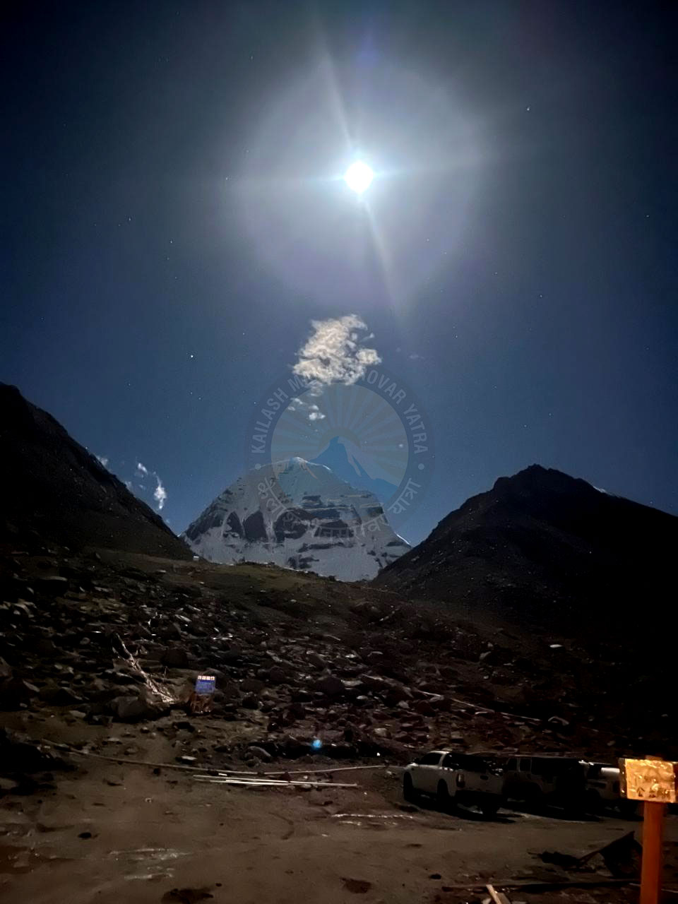 A single cloud floats above Mount Kailash under the full moon, illuminating the sacred Himalayan peak during the Kailash Mansarovar Yatra night journey.