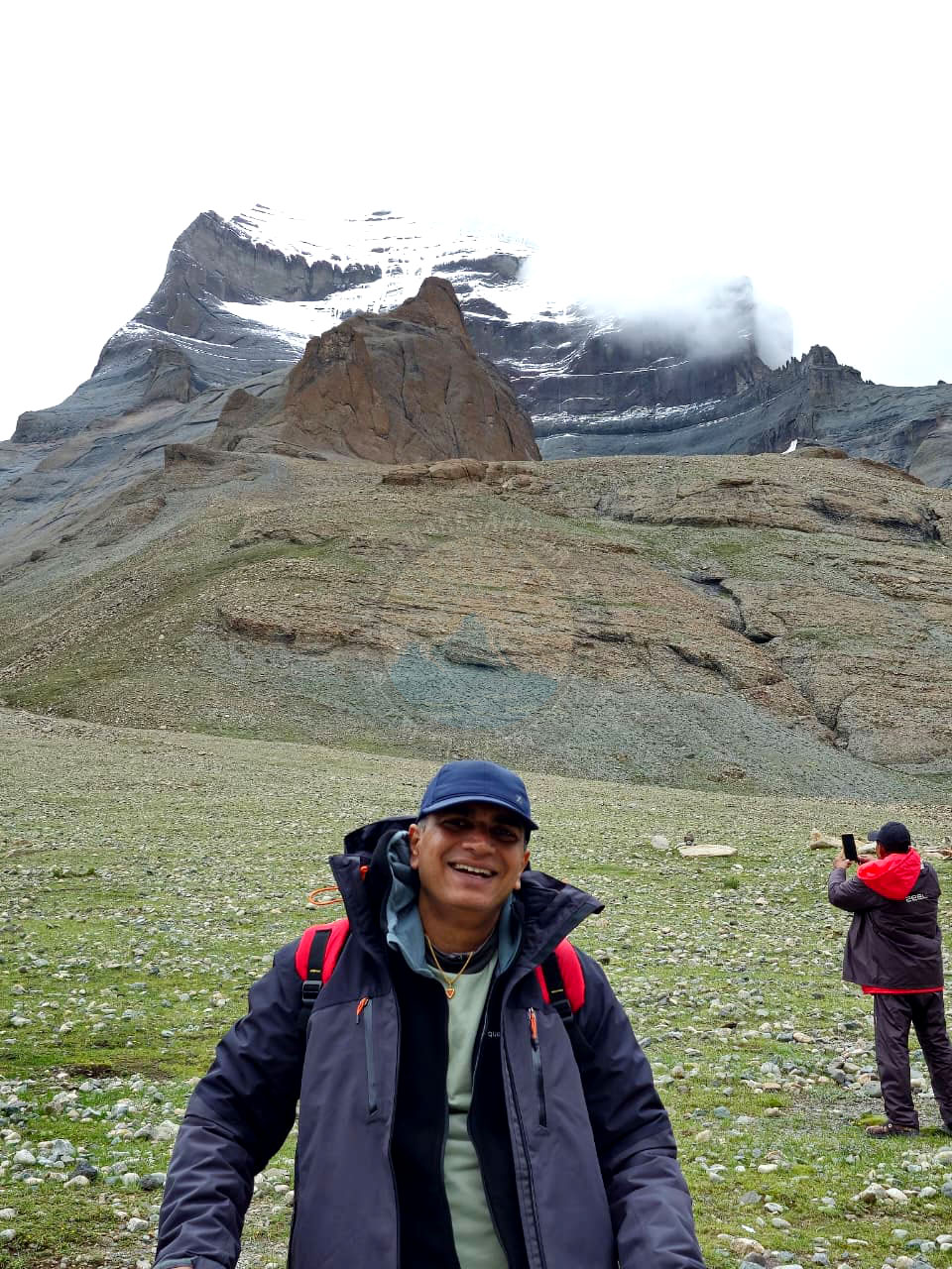 Happy pilgrim with Mount Kailash in the background during yatra, symbolizing spiritual peace and achievement