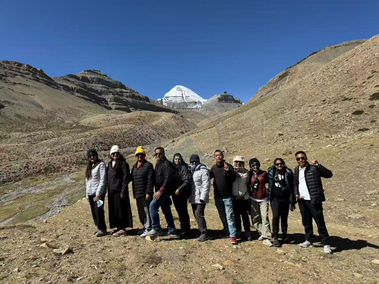 Pilgrims walking together on the challenging Mount Kailash Kora path, showing camaraderie and strength.