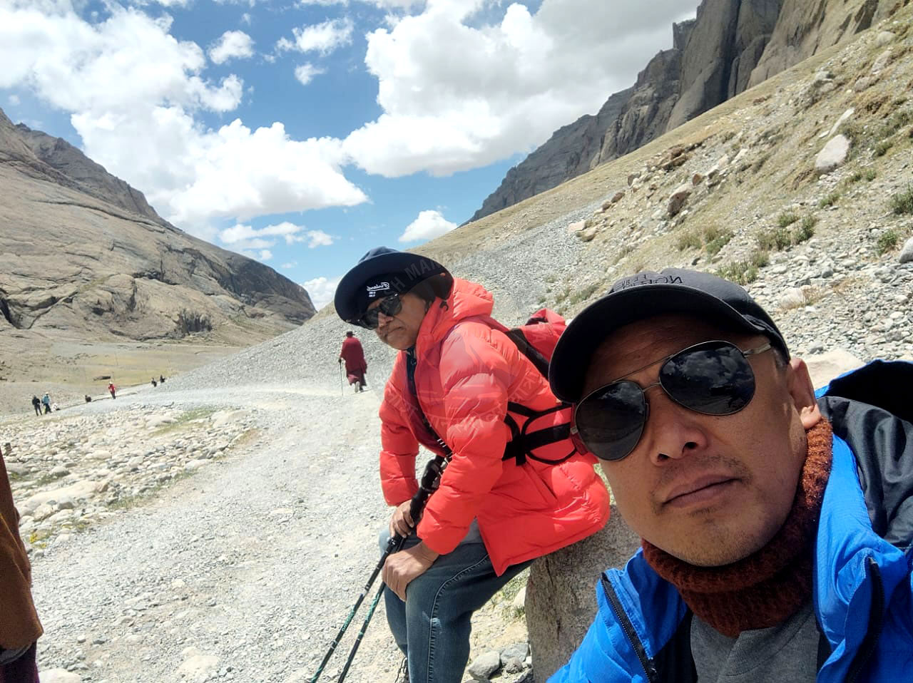 Pilgrims resting along the difficult Kailash Kora trail, showing determination and resilience