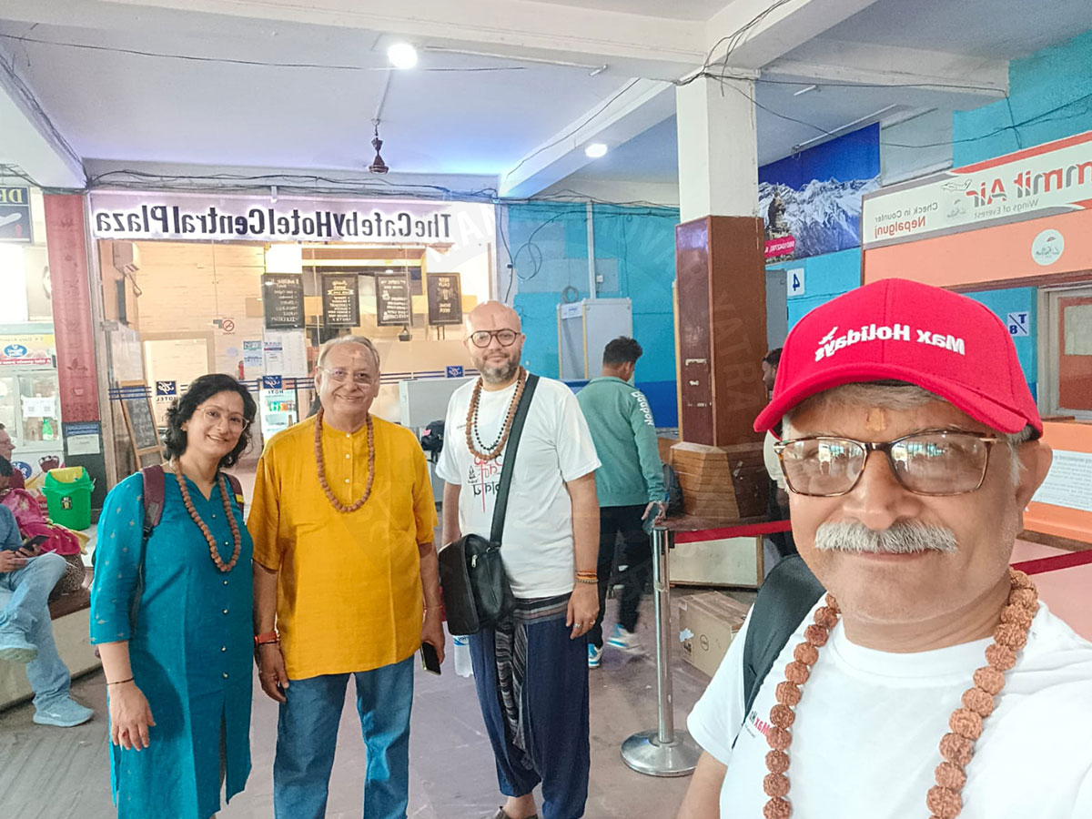 A group of people wearing rudraksha malas standing, ready for a pilgrimage or spiritual journey.