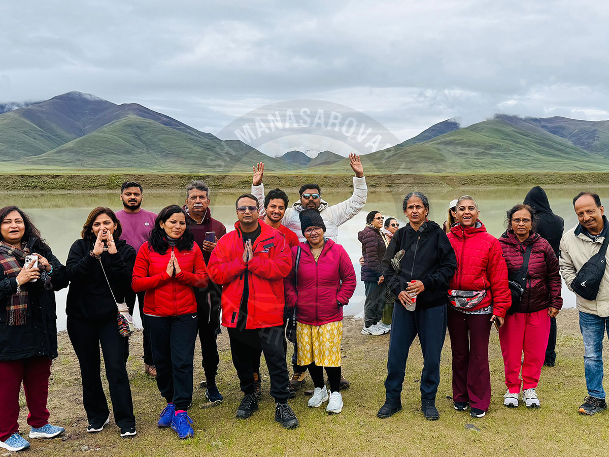 Devotees and travelers standing together during Kailash Mansarovar Yatra with Mount Kailash in the background